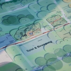 Ein Bauplan bzw. eine technische Projektgrafik liegt auf einem Tisch oder einer Unterlage; darüber ist eine transparente blaue Überlagerung mit Smartphone‑/Diagramm-Elementen zu sehen.