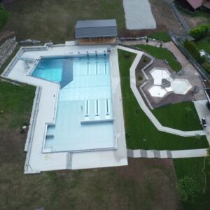 Luftaufnahme des sanierten Freibads Nordrach mit Schwimmbecken, Kinderbereich und angrenzenden Grünflächen.