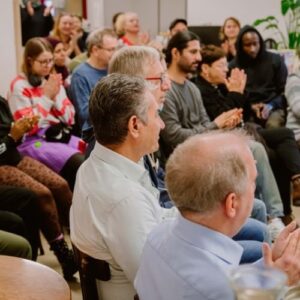 Zuhörerinnen und Zuhörer applaudieren nach einer Aufführung in einem Gemeinschaftsraum