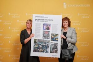 Zwei Preisträgerinnen präsentieren Projektplakat „Nachhaltige Fan Events in der Innenstadt“ beim Staatsanzeiger Award 2025.