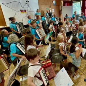 Kinder- und Jugendensemble mit Akkordeons probt gemeinsam in einem Saal