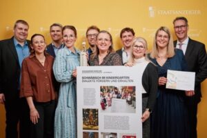 Team präsentiert Projekt „Schwäbisch im Kindergarten – Dialekte fördern und erhalten“ mit Plakat beim Staatsanzeiger Award 2025.