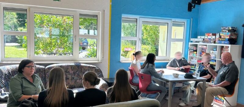 Jugendliche im Austausch mit Erwachsenen in einem Gemeinschaftsraum der Gemeinde