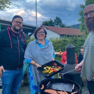 Bürgermeisterin und Helfer bereiten gemeinsam Grillgut bei einer Bürgerveranstaltung zu