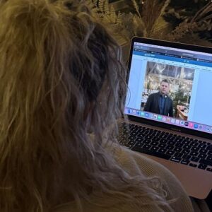 Nutzerin schaut sich ein Video-Update der Gemeinde-App auf einem Laptop an