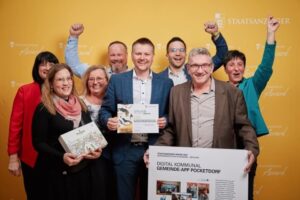 Gruppe von Markt Zeitlofs präsentiert Urkunde und Projektplakat zur Gemeinde-App „Pocketdorf“ beim Staatsanzeiger Award 2025.